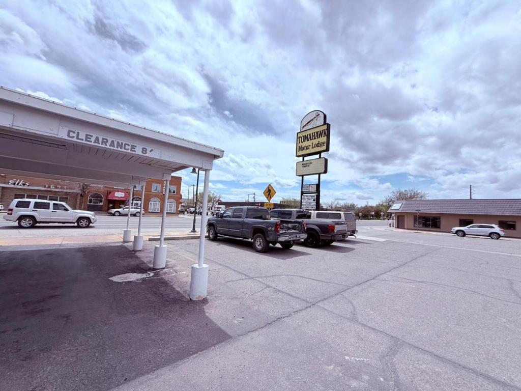 里弗顿Tomahawk Motor Lodge By OYO Riverton US-26的停泊在停车场的加油站,有卡车停泊