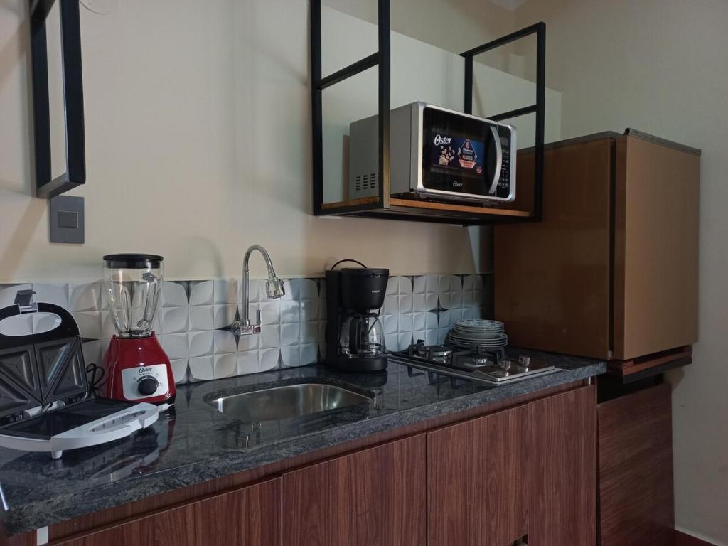 a kitchen counter with a sink and a microwave at Céntrico Departamento de 1 Dorm in Sucre