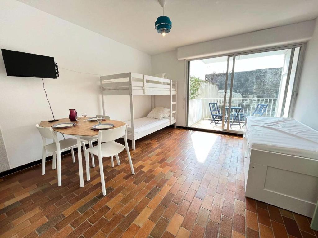 Cette chambre comprend une table et des lits superposés. dans l'établissement Résidence Le Vidourle - Studio 4 couchages au centre du Grau du Roi MAE-0973, au Grau-du-Roi