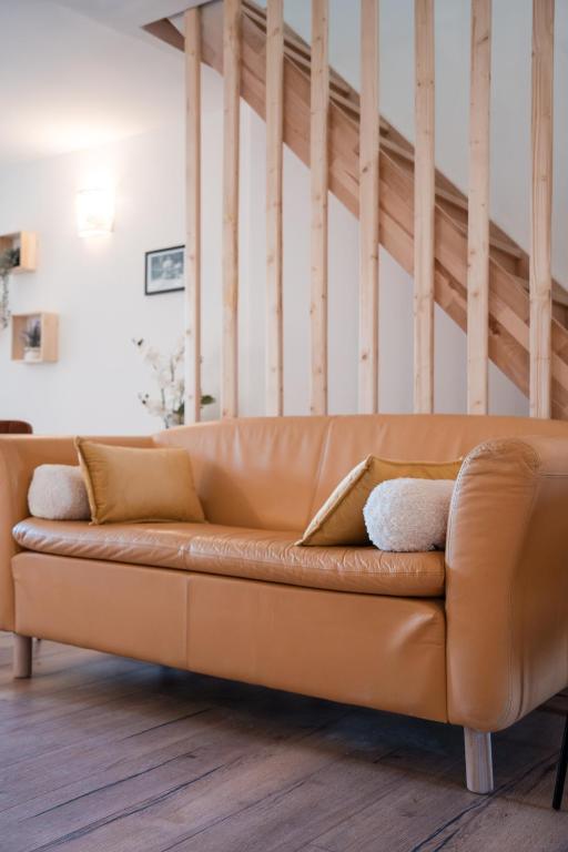 - un canapé en cuir brun dans le salon dans l'établissement Hygge en Méditerranée, à Salses-le-Chateau