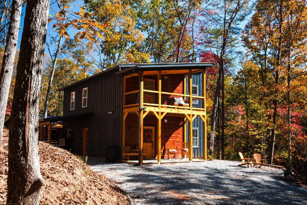 a house in the middle of a forest at Modern Luxe Cabin! River Fun, Deer, Pool & Firepit in Ellijay