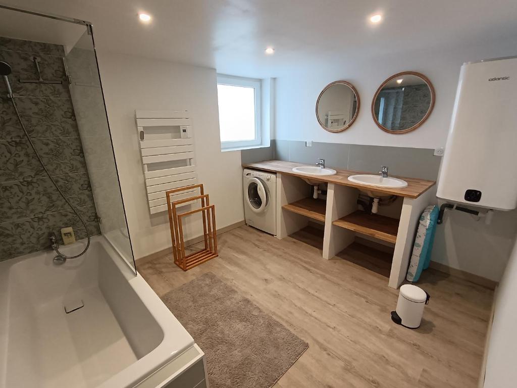 a bathroom with a tub and a sink and a washing machine at Les gîtes du Manoir de Camblain in Camblain-lʼAbbé