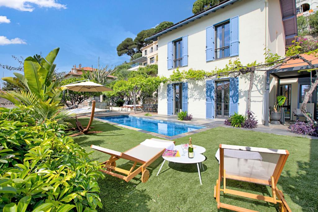 une cour arrière avec une table, des chaises et une piscine dans l'établissement Petit Paradis - Sea View, à Beaulieu-sur-Mer