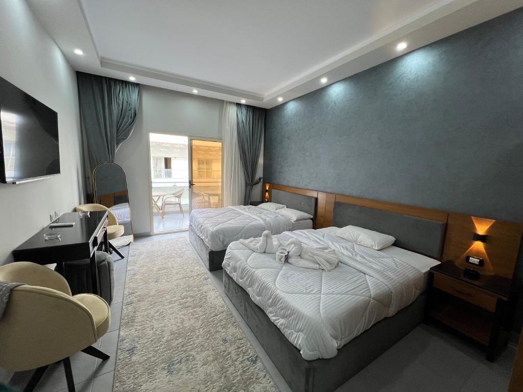 a hotel room with two beds and a desk at Luxury serviced apartments in Hurghada