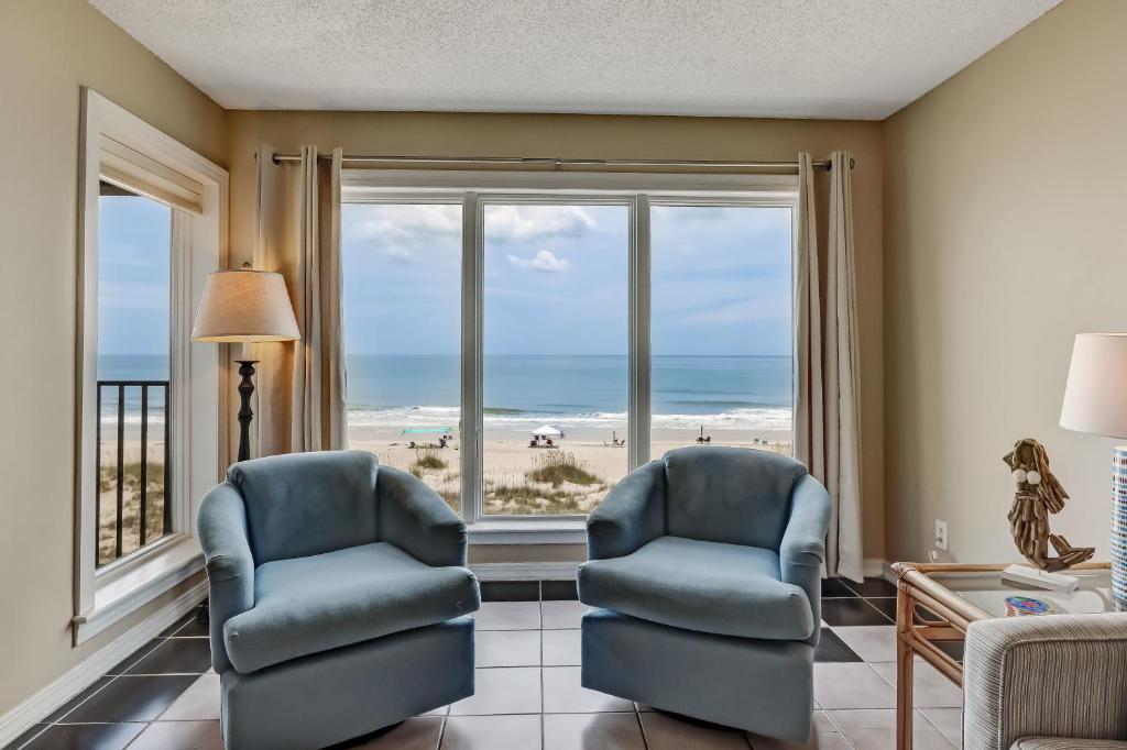 a living room with two chairs and a view of the beach at 2 Bed/2 Bath Oceanfront condo sleeps 6. Oceanfront deck and pool. in Fernandina Beach