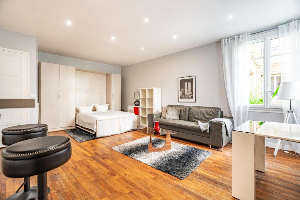 un salon avec un lit et un canapé dans l'établissement Elegant studio Saint-Dominique, à Paris