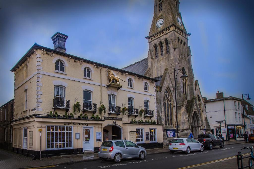a large building with a clock tower on top of it at The Golden Lion Hotel, St Ives, Cambridgeshire in St Ives