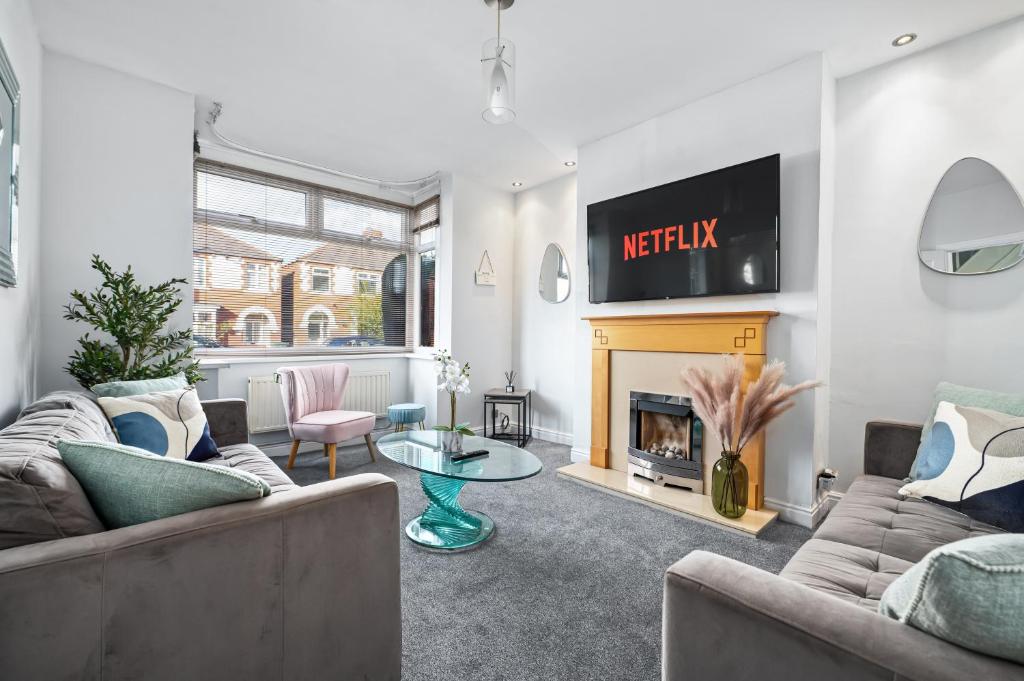 a living room with two couches and a fireplace at Stunning Modern Home 4 mins from Racecourse in Doncaster