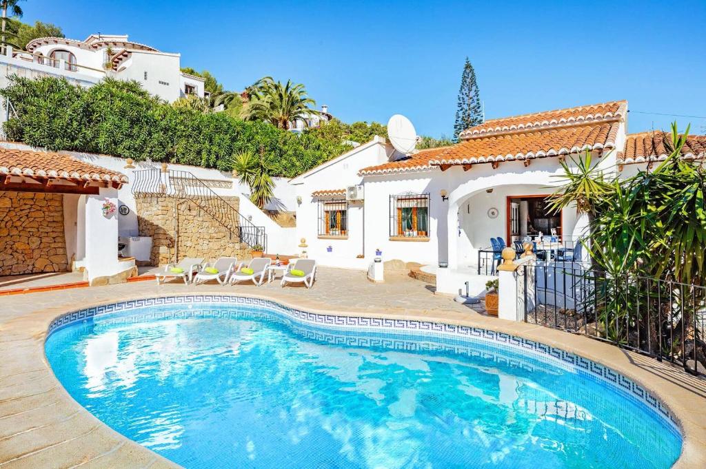 una piscina davanti a una casa di Villa Colbryca by Villa Plus a Cumbre del Sol