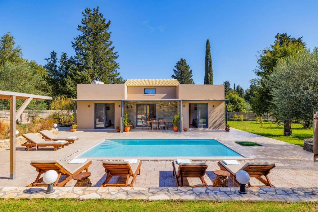 una villa con piscina di fronte a una casa di Villa Oras Corfu Thaleia by Villa Plus a Dassia