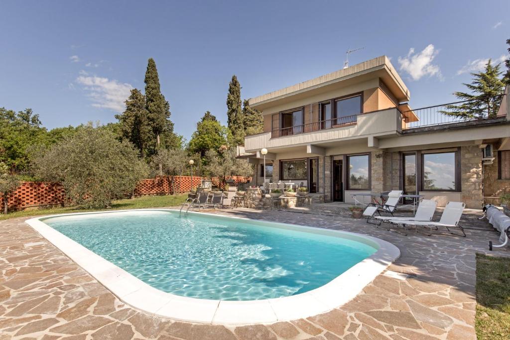 a house with a swimming pool in front of a house at Villa Ballodole in Florence