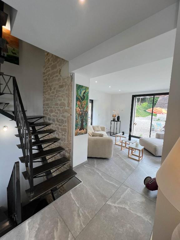 - un salon avec un escalier et un mur en pierre dans l'établissement Le Creux de Murmures, Lyon, à Maubec