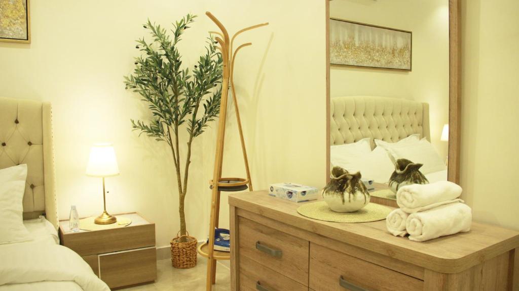 1 dormitorio con espejo y tocador con toallas en عمارة بروق 1 شقه 324, en Riad