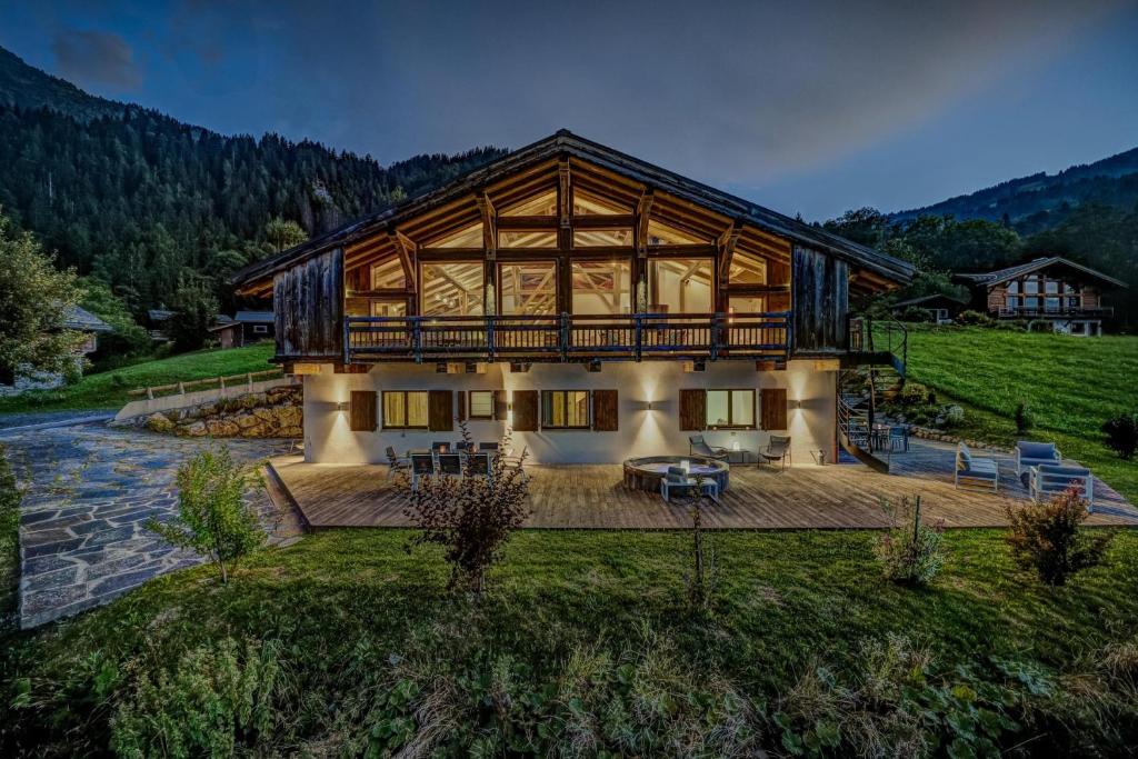 a large house with a large deck in a field at Chalet Norel in Les Houches