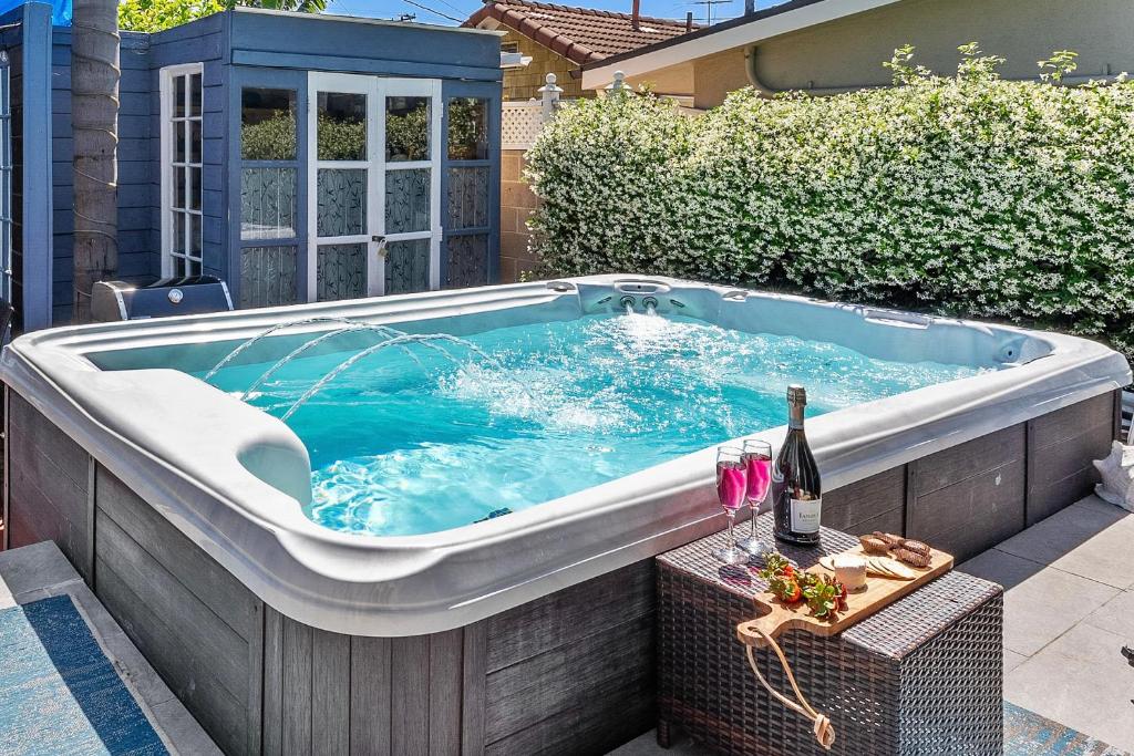 a hot tub in a backyard with a bottle of wine at Timeless Charm by the Coast, Vintage Beach Bungalow in Long Beach