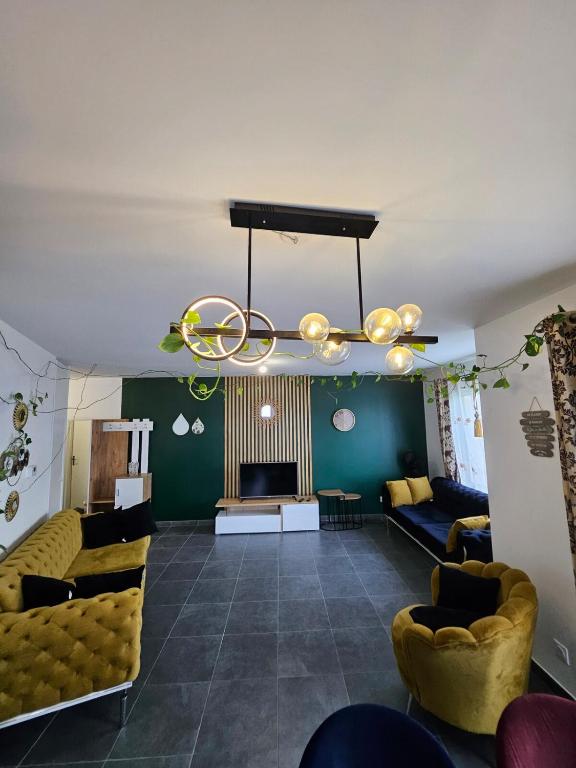 un salon avec des canapés et un lustre dans l'établissement Cozy Family, à Angers