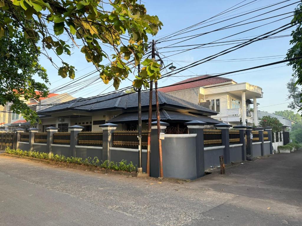 a building with a fence next to a street at Siloyo Homestay - Hommy place to stay! in Sasak Dua