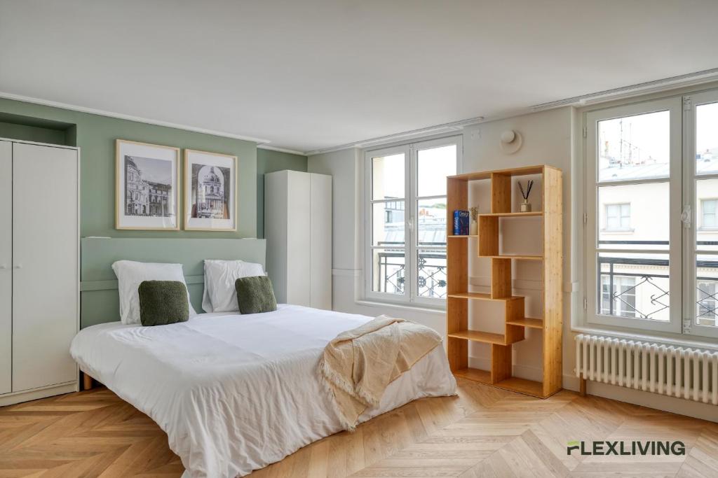 une chambre avec un grand lit blanc et des fenêtres dans l'établissement Beautiful Studio - Chauchat - Flexliving, à Paris