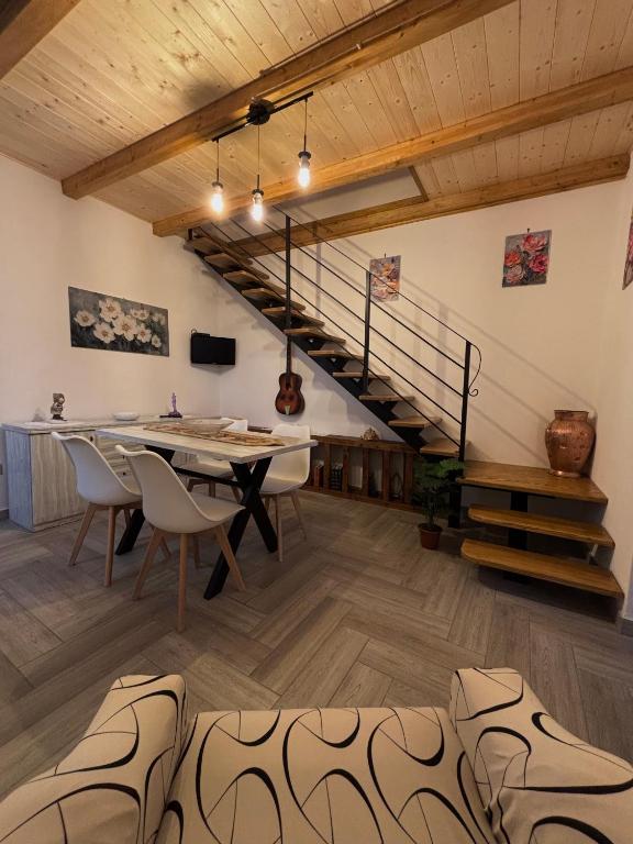 a dining room with a table and a staircase at Rosa Life House in Gasponi
