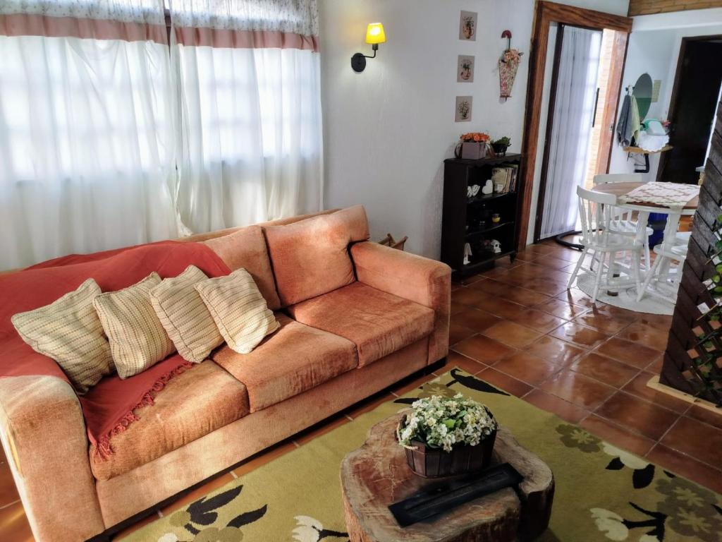 a living room with a couch and a table at Chalé Elohim Campos do Jordão in Campos do Jordão