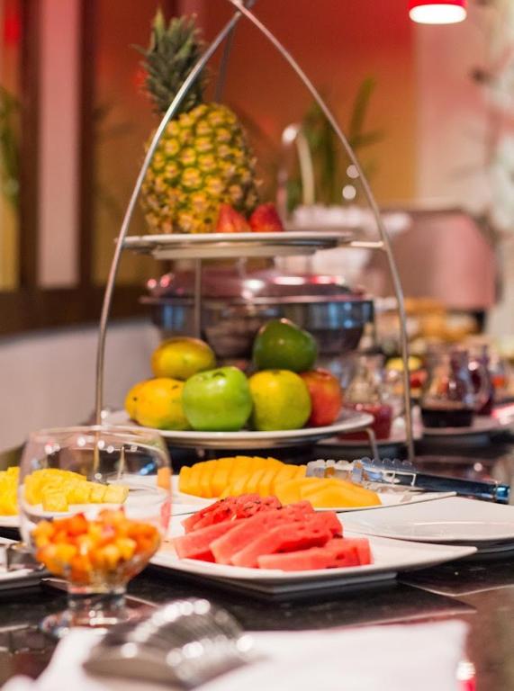 um buffet de frutas e vegetais numa mesa em Novelty Suites Hotel em Medellín
