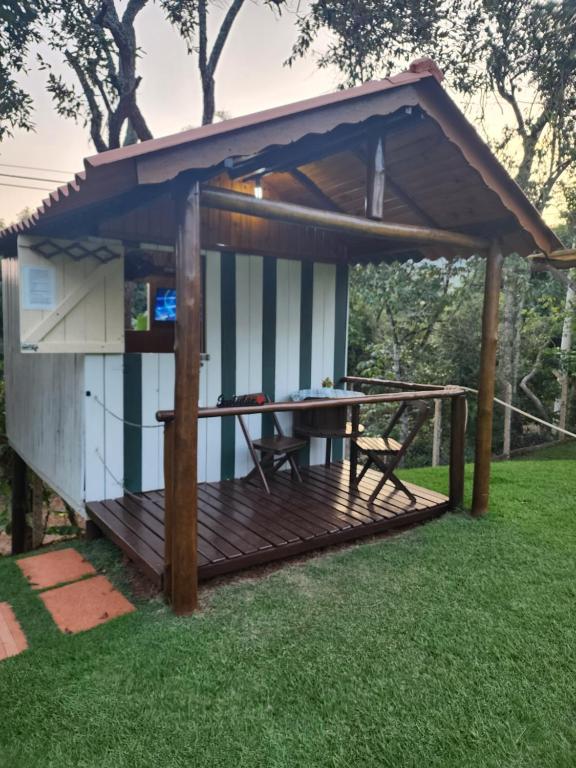 einen Pavillon mit einem Tisch im Gras in der Unterkunft Cabana Hostel nas Árvores EcoPark in São Pedro