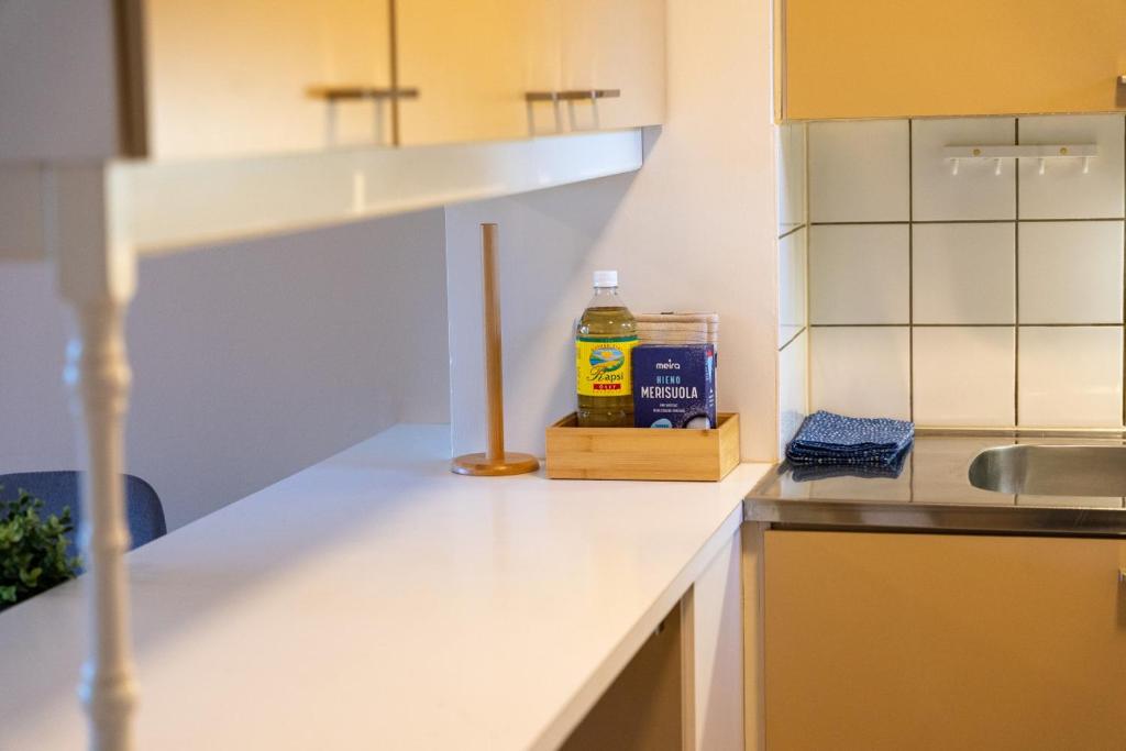 a kitchen counter with a bottle of honey and a sink at Cosy one bedroom apartment with balcony in Rovaniemi