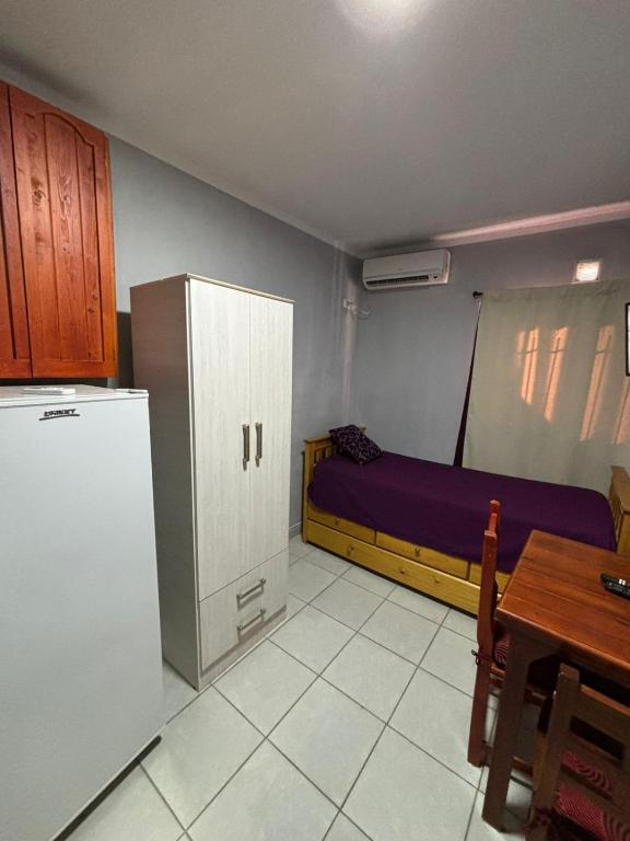 cocina con nevera, mesa y cama en El sol, en Recreo