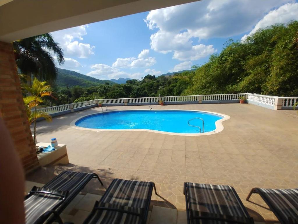 einen Pool auf einer Terrasse mit 2 Stühlen in der Unterkunft Essential Life La Cuaba Casa de Campo Amenities in Pedro Brand