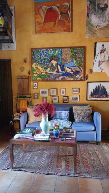a living room with a blue couch and a table at Vila Santa Rosa Guest House in Ilhabela