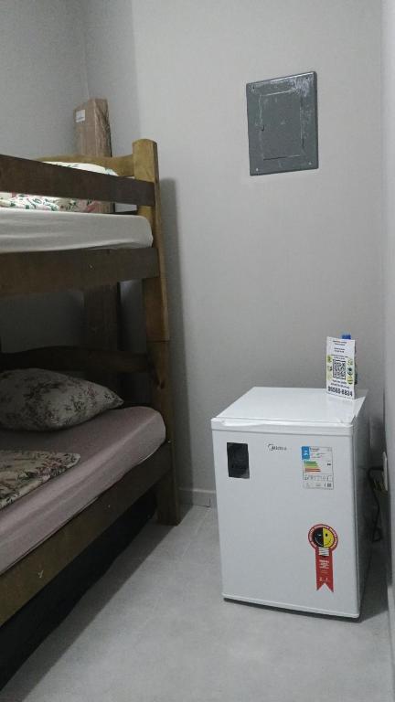 a small refrigerator sitting next to a bunk bed at Hospedagem Cinelândia AP 617 in Rio de Janeiro