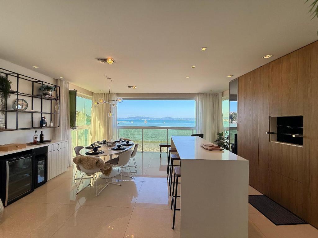 a kitchen with a table and a large window at IL01- Vista Mar | Pé na Areia | Churrasqueira in Itapema
