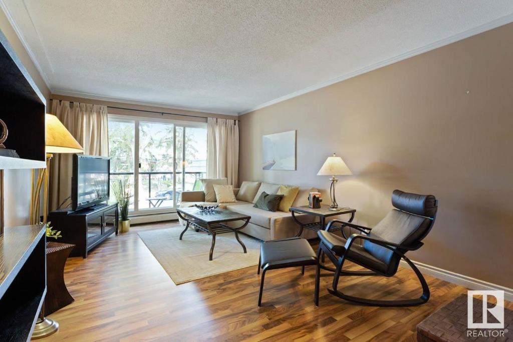 a living room with a couch and a table at Condo Unit-UofA, UofA Hospital, Whyte Ave, Trails! in Edmonton