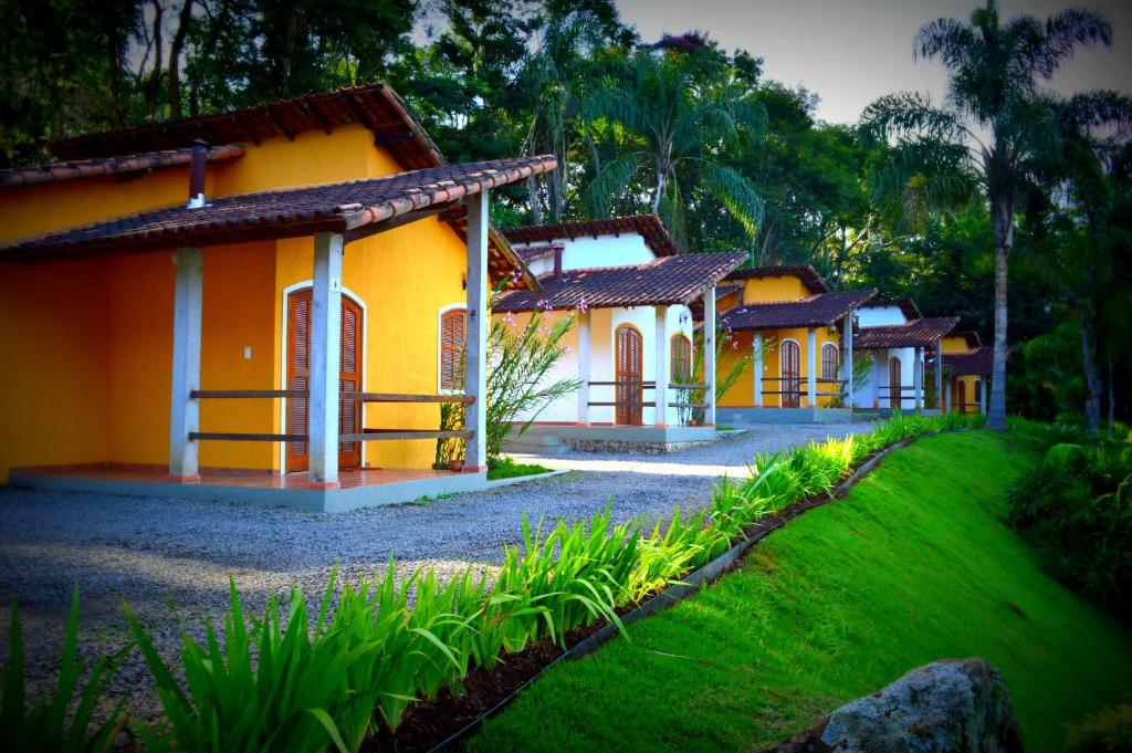 una fila de casas en un patio con césped en Pousada Lago das Pedras, en Juiz de Fora