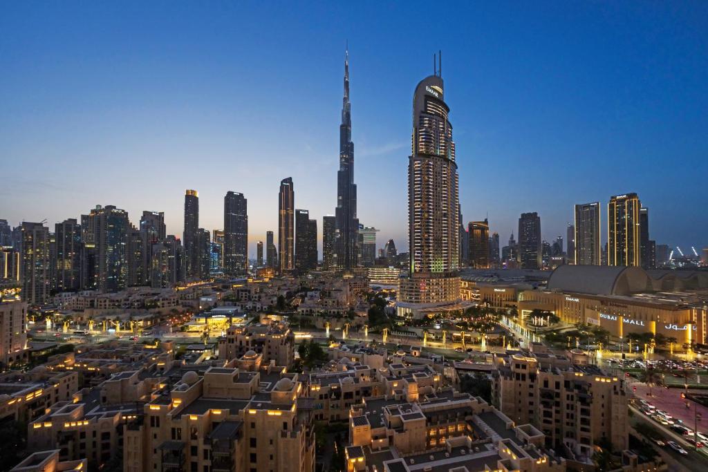a view of a city at night with a tall skyscraper at Burj Royale Lux 2-bedroom apartment with the best Burj Khalifa view in Dubai