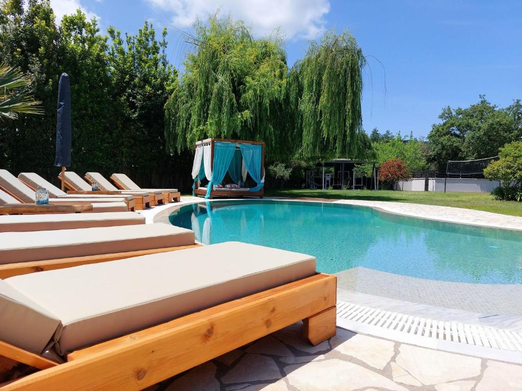 a swimming pool with lounge chairs and a swimming pool at Villa Black White Dassia in Dassia