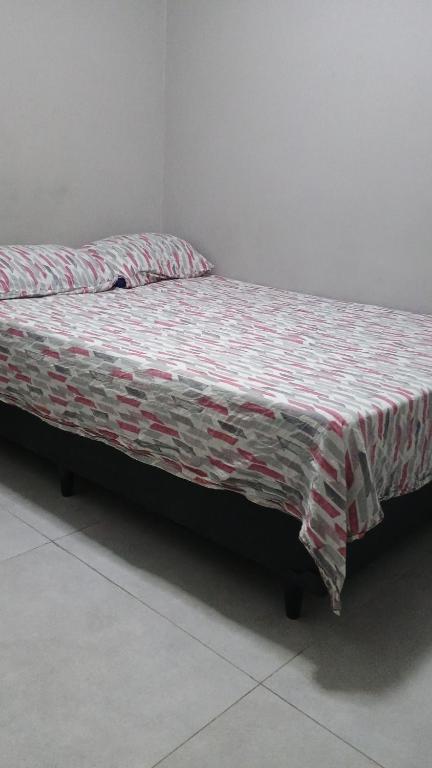 a bed with a comforter on it in a room at Hospedagem Cinelândia AP 617 in Rio de Janeiro