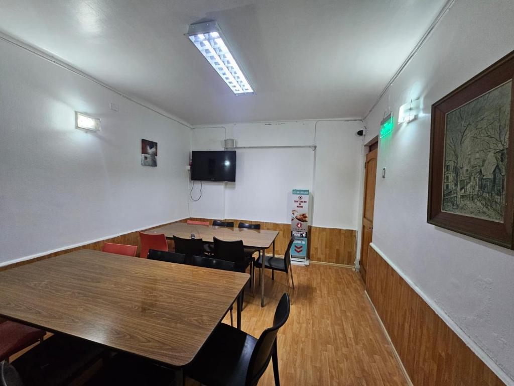 Una sala de conferencias con mesas y sillas y un gran cuadro en la pared. en Hostal G&P, en Antofagasta