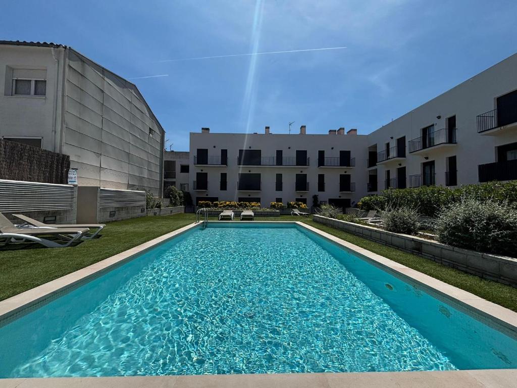ein Schwimmbad vor einem Gebäude in der Unterkunft Apartamento céntrico con piscina, parking y a 200m de la playa en L'Estartit - ES-323-41 in L'Estartit