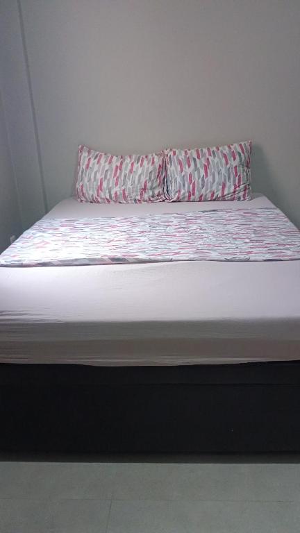 a bed with a pillow on top of it at Hospedagem Cinelândia AP 617 in Rio de Janeiro