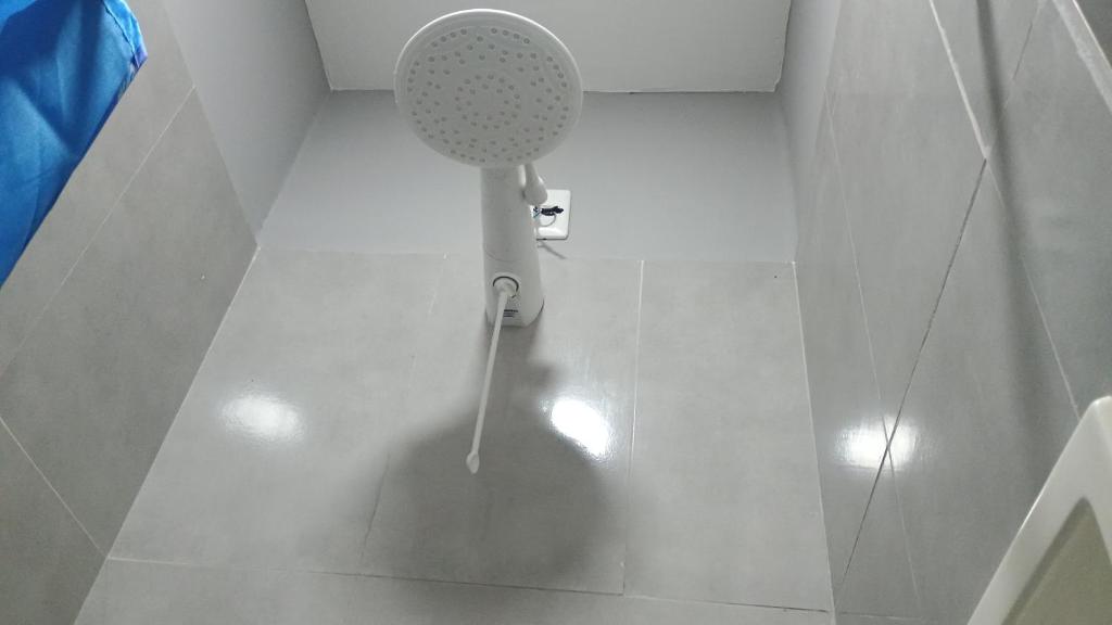 a white bathroom with a shower with a shower at Hospedagem Cinelândia AP 617 in Rio de Janeiro