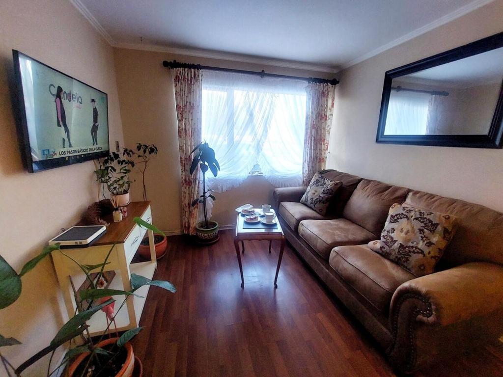 una sala de estar con un sofá y una mesa en Amplio Departamento en Centro de Concepción con estacionamiento 2D-2B, en Concepción