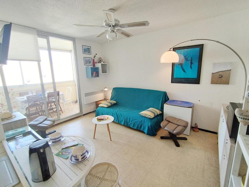 un salon avec un canapé bleu et une table dans l'établissement Appartement T3 proche plage et commerces - 6 personnes - Narbonne-Plage - FR-1-795-66, à Narbonne