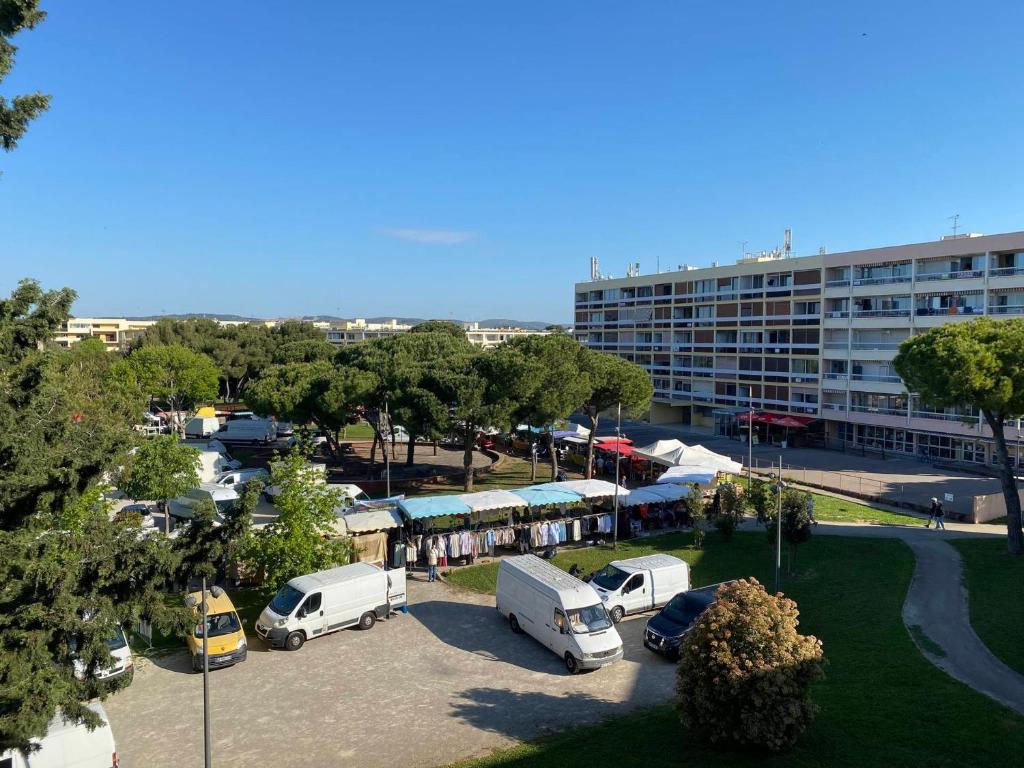 un parking avec des véhicules garés devant un bâtiment dans l'établissement Studio 2 Pers à Balaruc-les-Bains, Animaux Ok, Climatisé - FR-1-503-186, à Balaruc-les-Bains