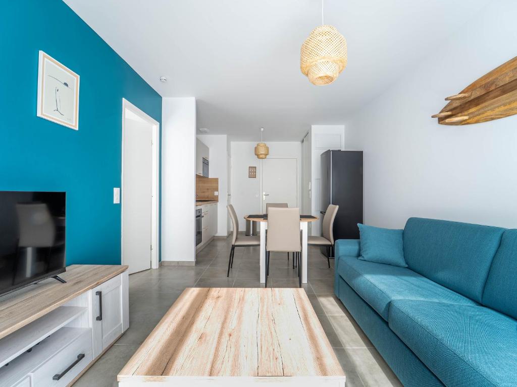 un salon avec un canapé bleu et une table dans l'établissement Mimizan Plage - T2 équipé à 400m océan, parking, 4 pers. - FR-1-50-178, à Mimizan