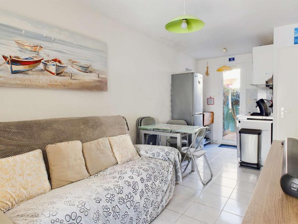 un salon avec un canapé et une cuisine dans l'établissement Maison mitoyenne 5 pers, chambres climatisées, parking, animaux, wifi inclus - FR-1-326-859, à Marseillan