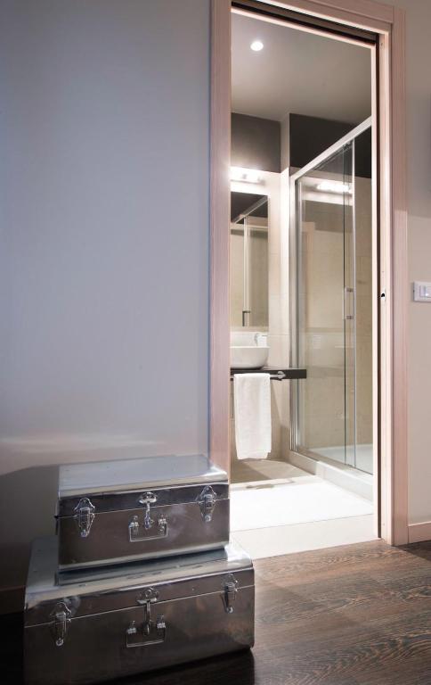 a bathroom with two suitcases in front of a mirror at Hotel B&B il Mosaico in Sirmione