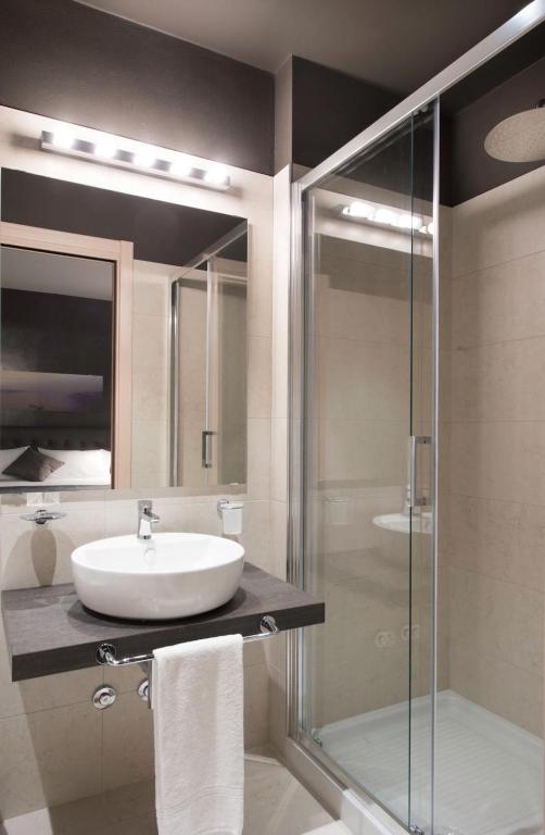 a bathroom with a sink and a glass shower at Hotel B&B il Mosaico in Sirmione