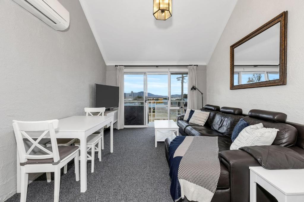 a living room with a couch and a table at Parkwood 5 - 2BR Split Level l Spa Bath l BBQ l Central Location l WiFi in Jindabyne