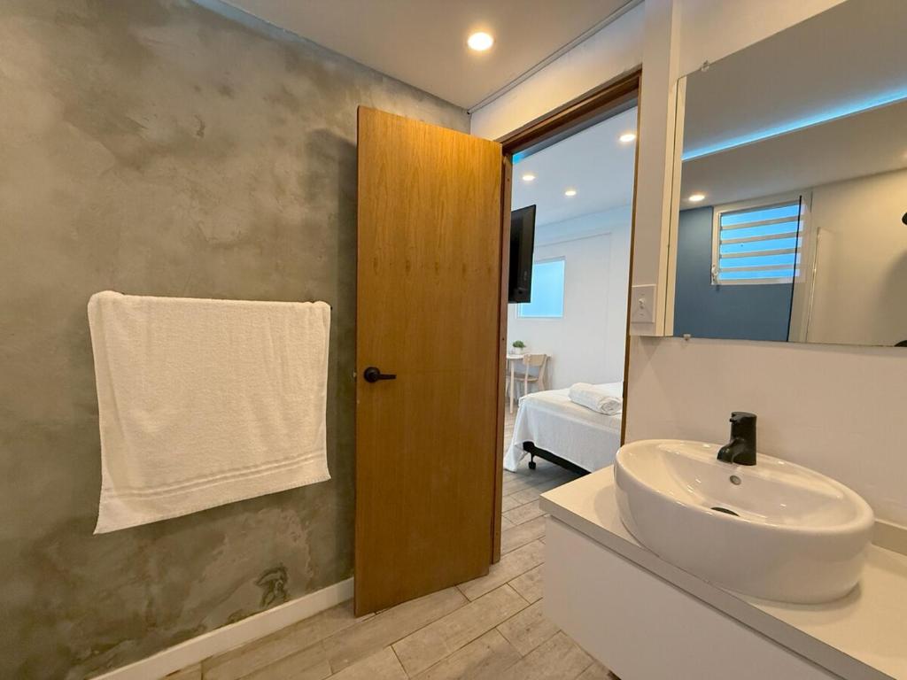a bathroom with a sink and a mirror at New! Cozy Cool Studio Near Beach! in San Juan
